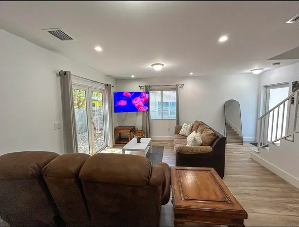 a living room with furniture and a wooden floor