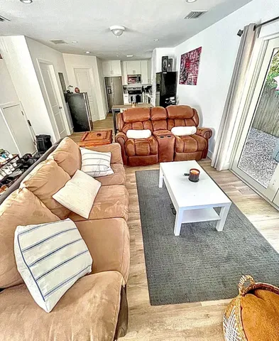 a living room with furniture and wooden floor