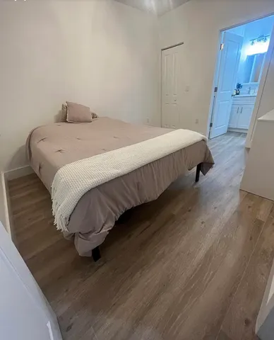 a bedroom with a bed and wooden floor