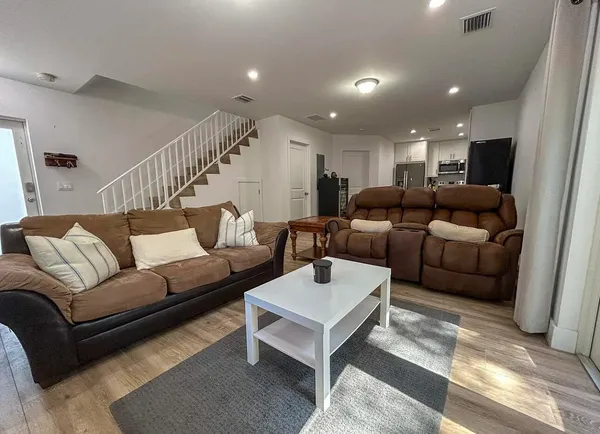 a living room with furniture and a wooden floor