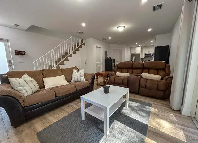 a living room with furniture and a wooden floor