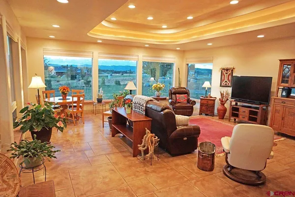a living room with patio furniture and a flat screen tv