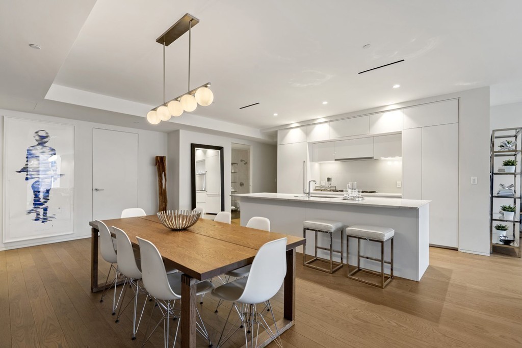 10 Farnsworth Street, Unit 5B Boston, MA 02210 - Photo 4 of 35 a dining room with a table chairs and a kitchen view