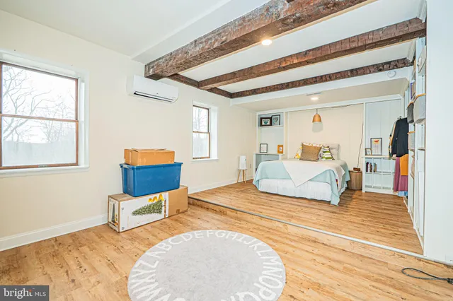 a bedroom with a bed and a wooden floor