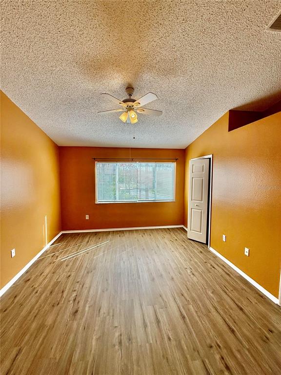 29920 Playa Del Rey Lane Wesley Chapel, FL 33543 - Photo 10 of 32 wooden floor in an empty room with a window