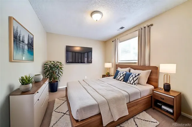 a bedroom with a bed and a potted plant