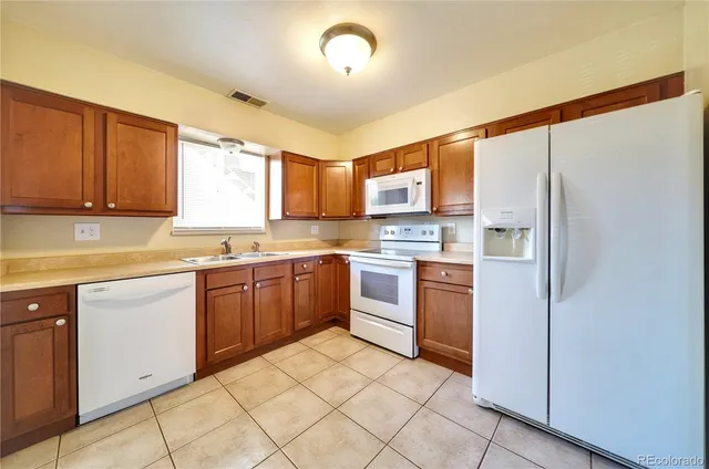 a kitchen with a refrigerator sink and cabinets