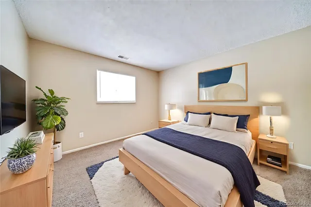 a bedroom with a bed and a potted plant