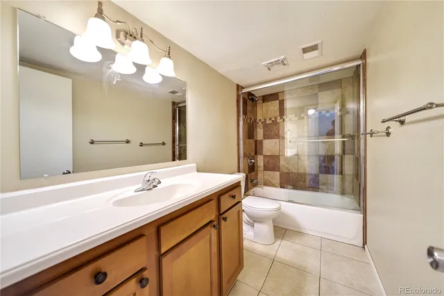 a bathroom with a sink a toilet a mirror and shower