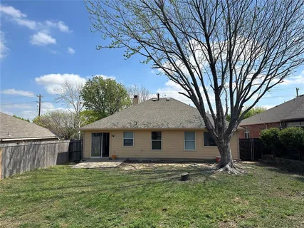 a view of a yard in front of a house with large tree