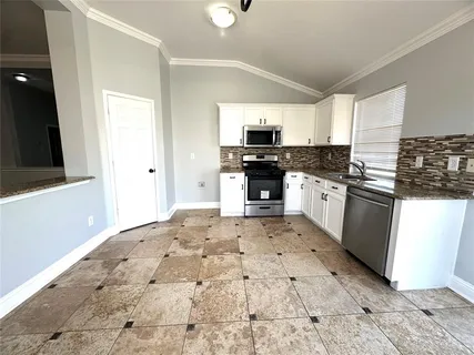 a large kitchen with stainless steel appliances granite countertop a sink and stove top oven