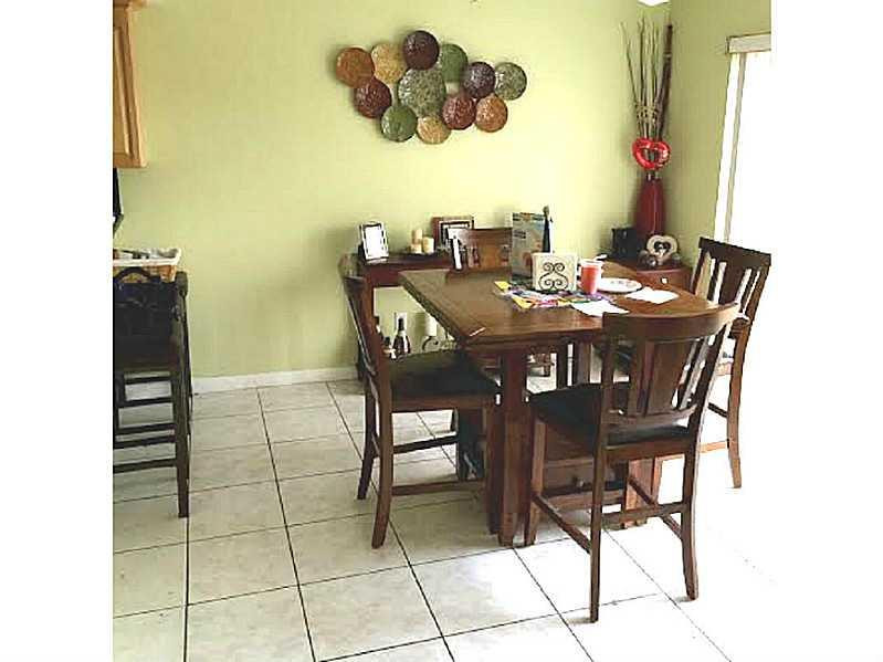 8509 Boca Rio Drive, Unit 8509 Boca Raton, FL 33433 - Photo 9 of 16 a view of a dining room with furniture and chandelier