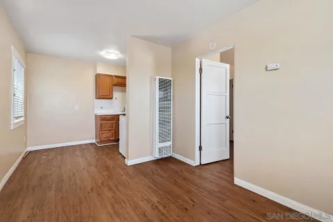 a view of an empty room with wooden floor and entryway