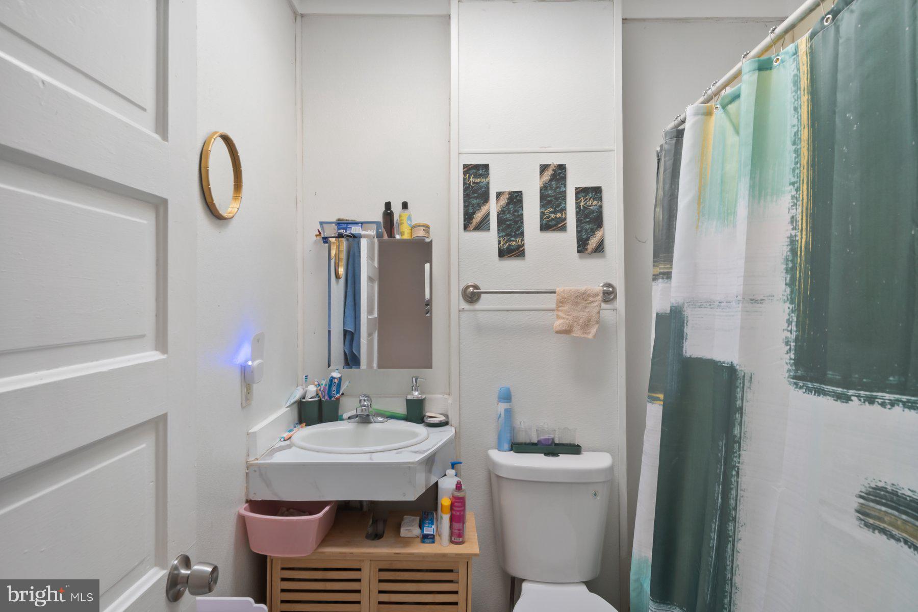 1659 Cliftview Avenue Baltimore, MD 21213 - Photo 14 of 25 a bathroom with a sink a toilet and shower