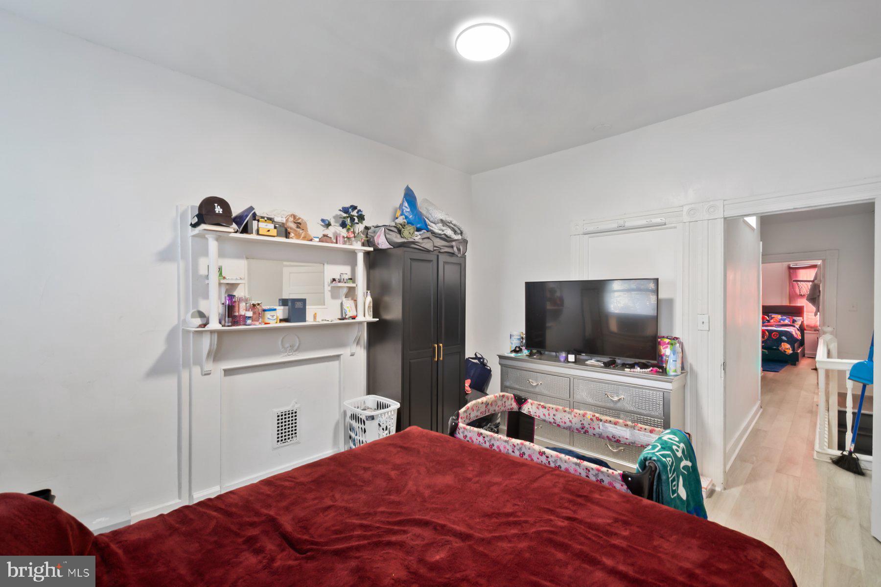 1659 Cliftview Avenue Baltimore, MD 21213 - Photo 19 of 25 a bedroom with a bed and a flat screen tv