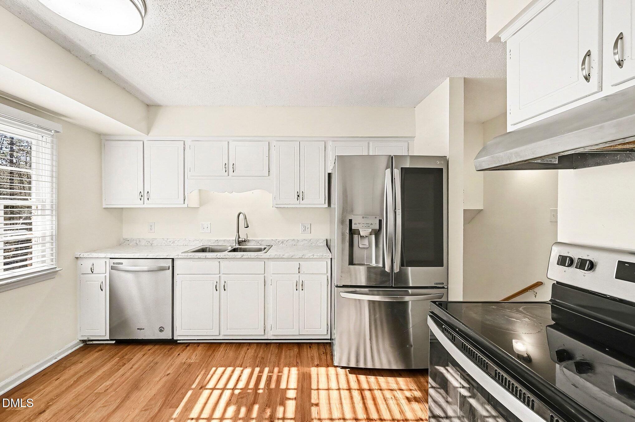 1920 White Plains Road Chapel Hill, NC 27517 - Photo 9 of 31 a kitchen with kitchen island granite countertop a sink cabinets and stainless steel appliances