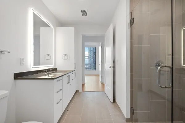 a bathroom with a granite countertop sink a toilet and shower