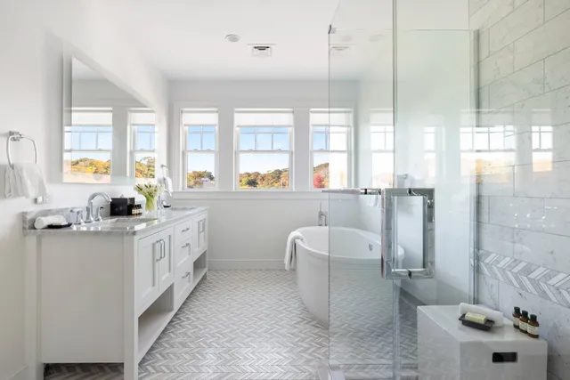 a large white kitchen with a large window and sink