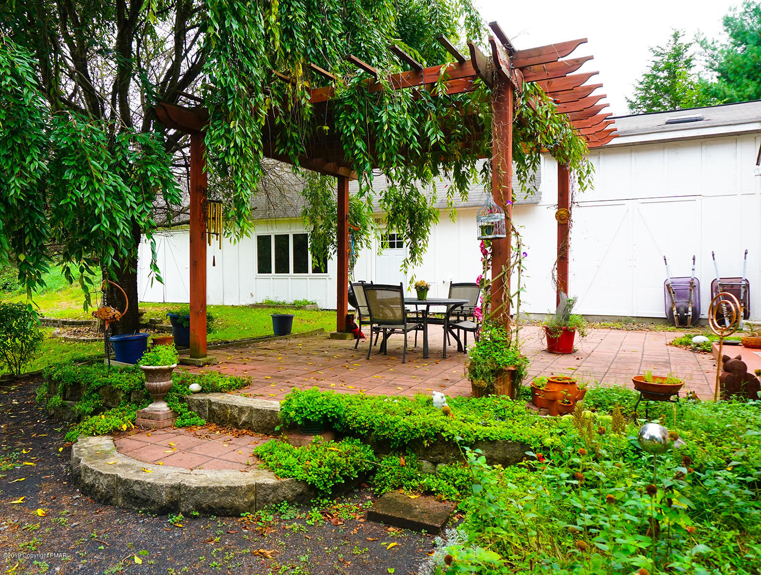 829 Gilbert Road Effort, PA 18330 - Photo 21 of 48 a view of a patio with table and chairs potted plants and large tree