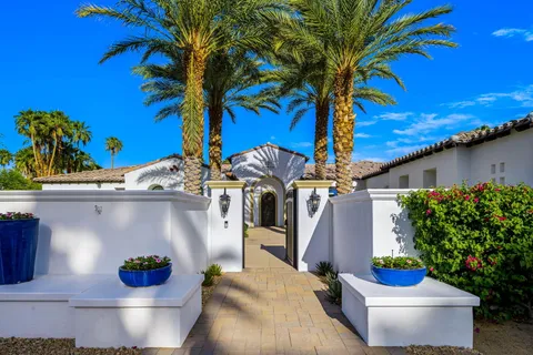 a kitchen with stainless steel appliances kitchen island granite countertop a table chairs refrigerator and microwave