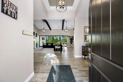 a kitchen with stainless steel appliances granite countertop a refrigerator a sink dishwasher a stove and white cabinets with wooden floor
