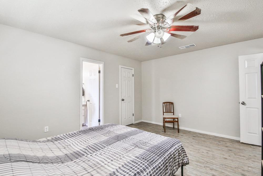 5503 1st Place Lubbock, TX 79416 - Photo 20 of 27 a bedroom with a bed and a chandelier