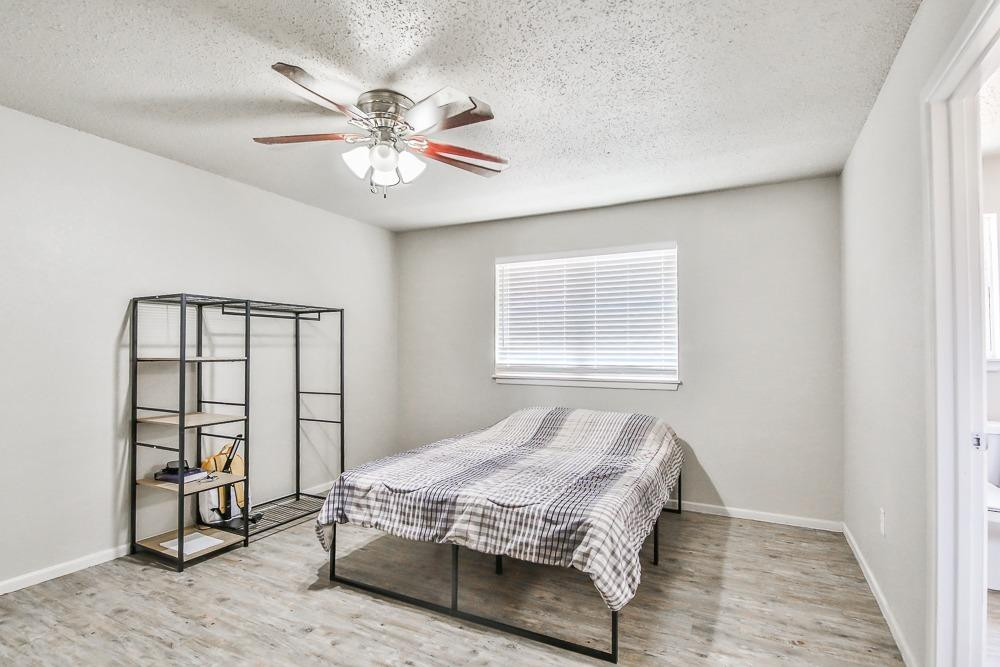 5503 1st Place Lubbock, TX 79416 - Photo 21 of 27 a bedroom with a bed a dresser and a window