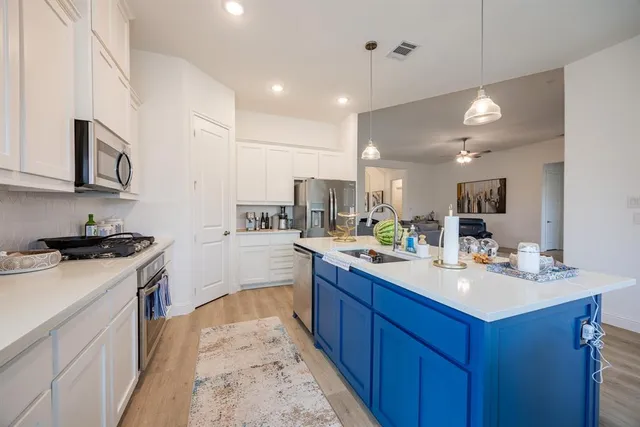 a kitchen with a sink stove and cabinets