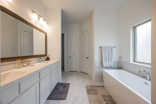 a bathroom with a tub sink and mirror