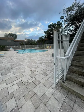a view of a house with a yard and potted plants