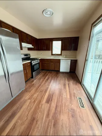 a view of kitchen with wooden floor and electronic appliances