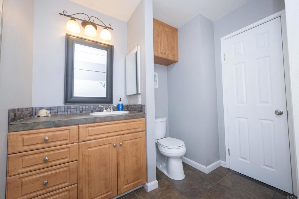 929 Jamacha Road, Unit B El Cajon, CA 92019 - Photo 27 of 36 a bathroom with a granite countertop toilet a sink and a mirror