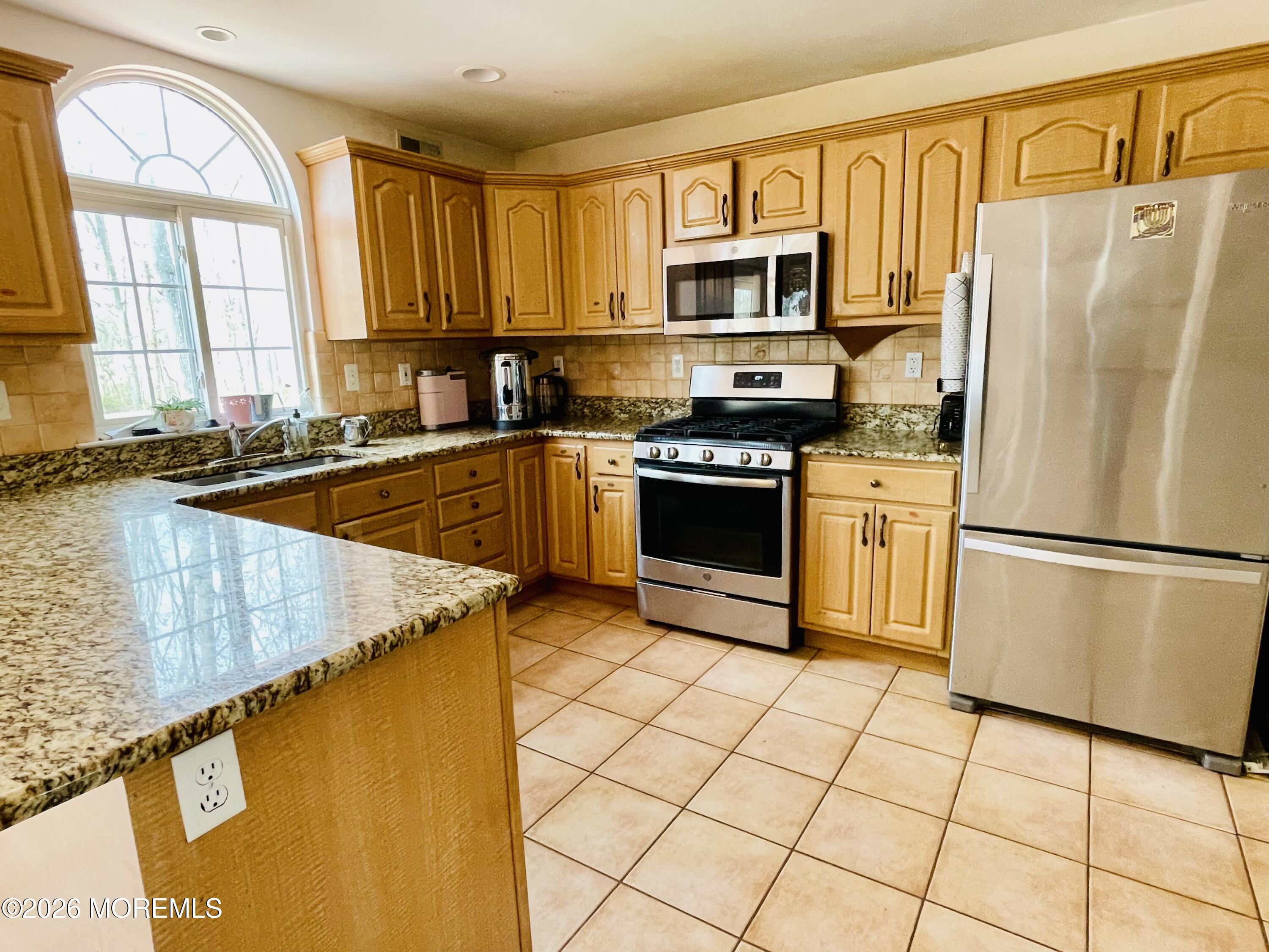 405 Lawrence Avenue Oakhurst, NJ 07755 - Photo 4 of 23 a kitchen with stainless steel appliances granite countertop a refrigerator sink and stove