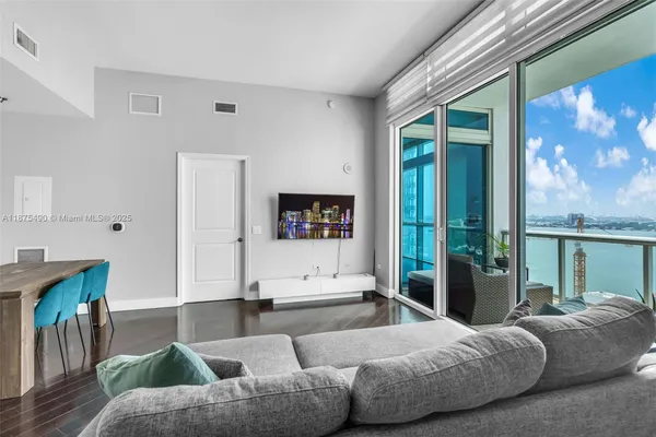 a living room with furniture and a floor to ceiling window