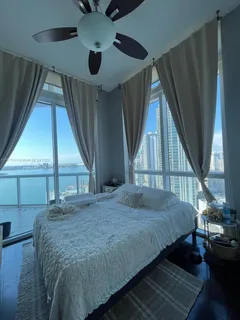 a bedroom with a bed and a large window