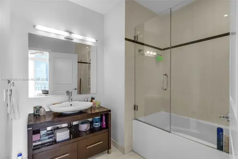 a bathroom with a double vanity sink mirror and shower