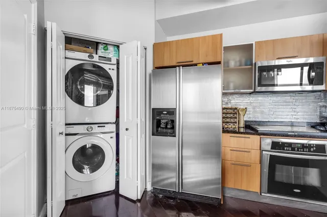 a kitchen with stainless steel appliances granite countertop a refrigerator and a stove top oven