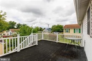a view of a white house with a small yard and floor to ceiling window