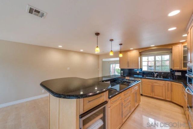 a large kitchen with granite countertop a large counter top covered in it and stainless steel appliances