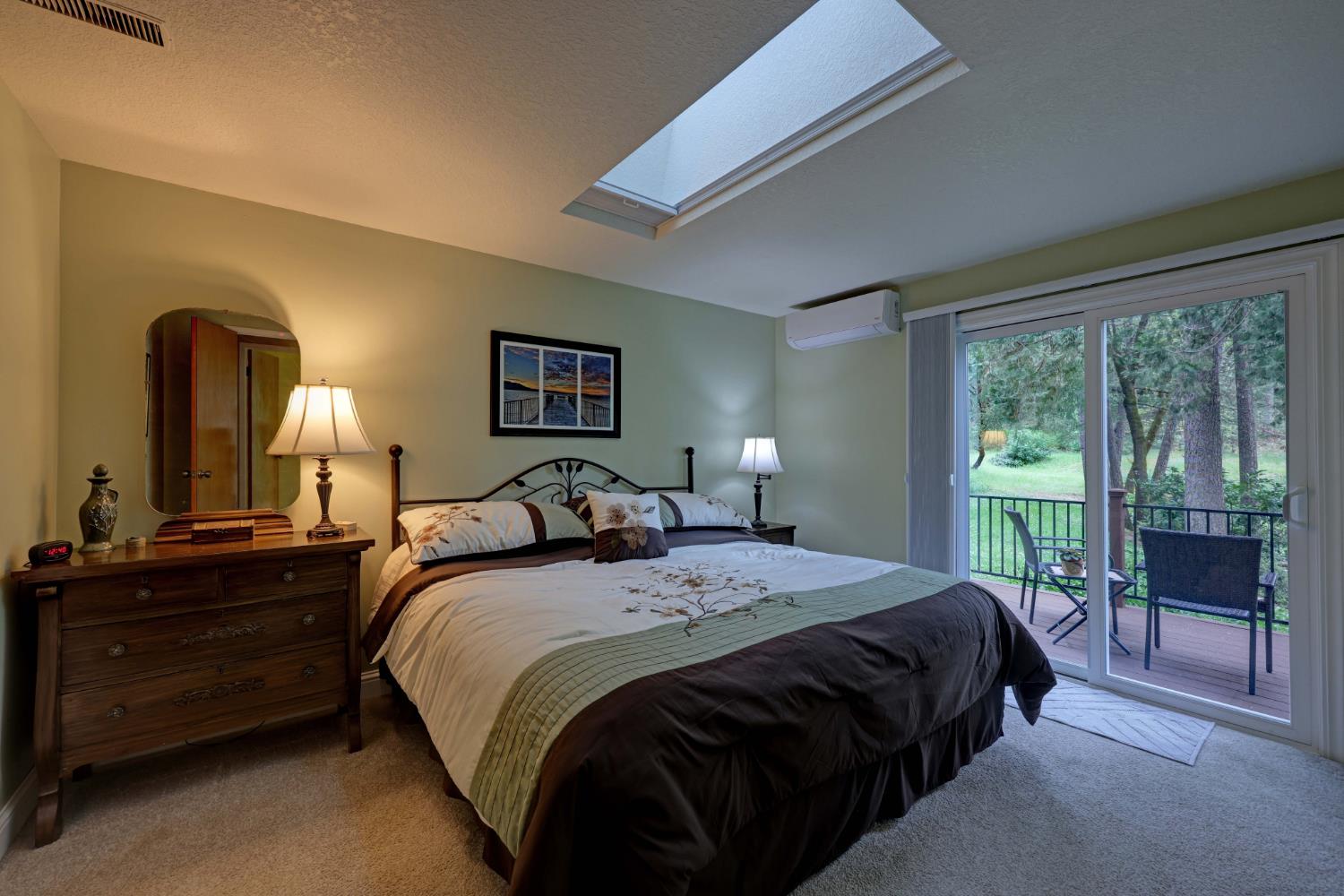 409 Live Oak Road Colfax, CA 95713 - Photo 26 of 74 Primary suite with retractable cover on skylight and deck access to a fabulous view of the pond and acreage.