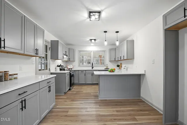 a large kitchen with cabinets and wooden floor