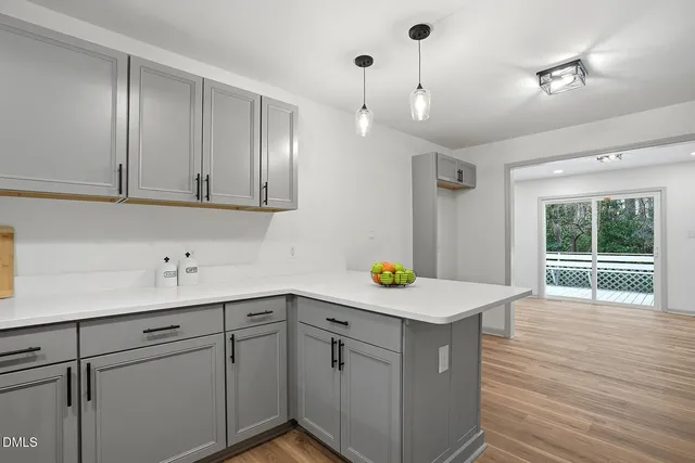 a kitchen with a sink cabinets and wooden floor