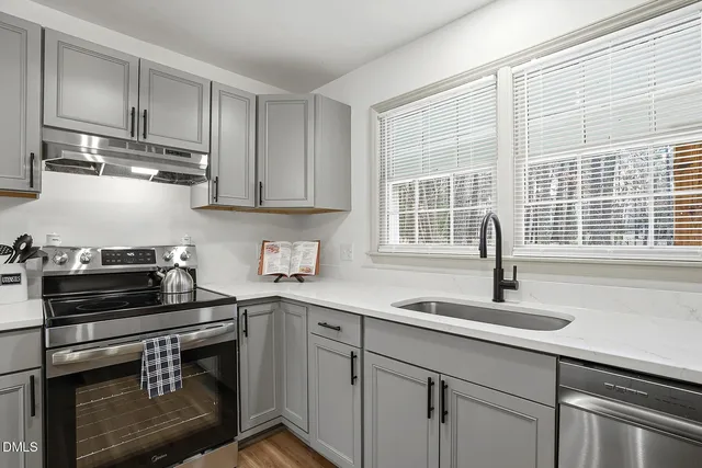 a kitchen with stainless steel appliances a stove a sink and cabinets