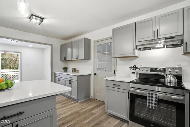 a kitchen with cabinets wooden floor and stainless steel appliances