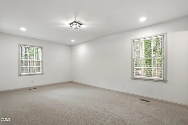 an empty room with a empty space and windows