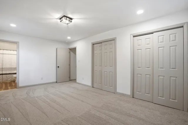 an empty room with closet and a chandelier fan