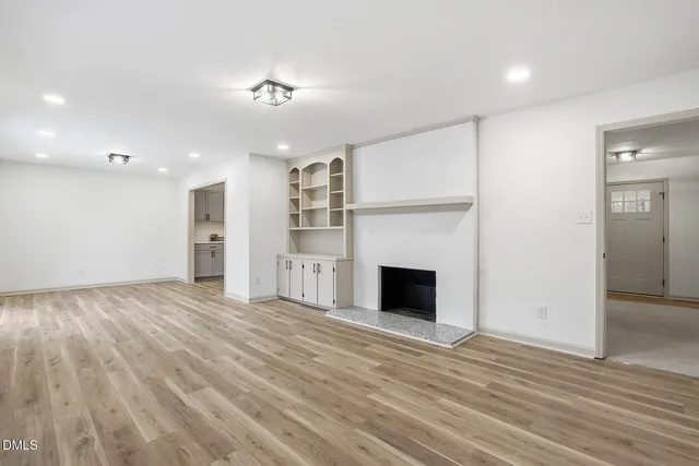 a view of an empty room with a fireplace and a window