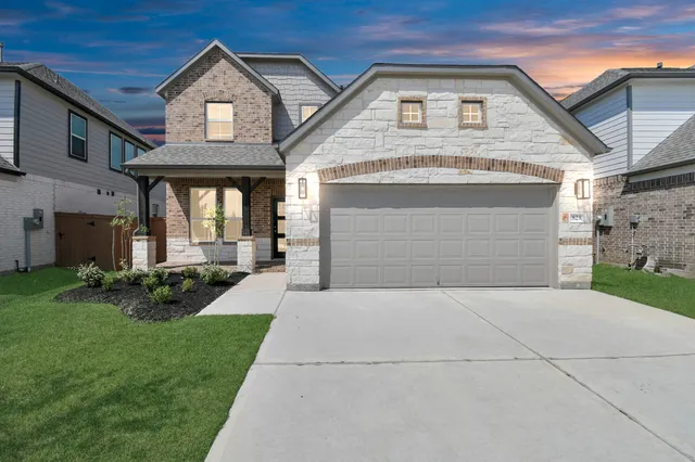 a front view of a house with a yard and garage