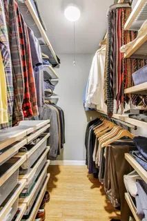 a view of walk in closet with clothes and shoes