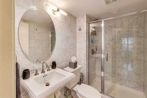 a bathroom with a sink a toilet and shower